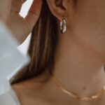 woman in white shirt wearing gold necklace